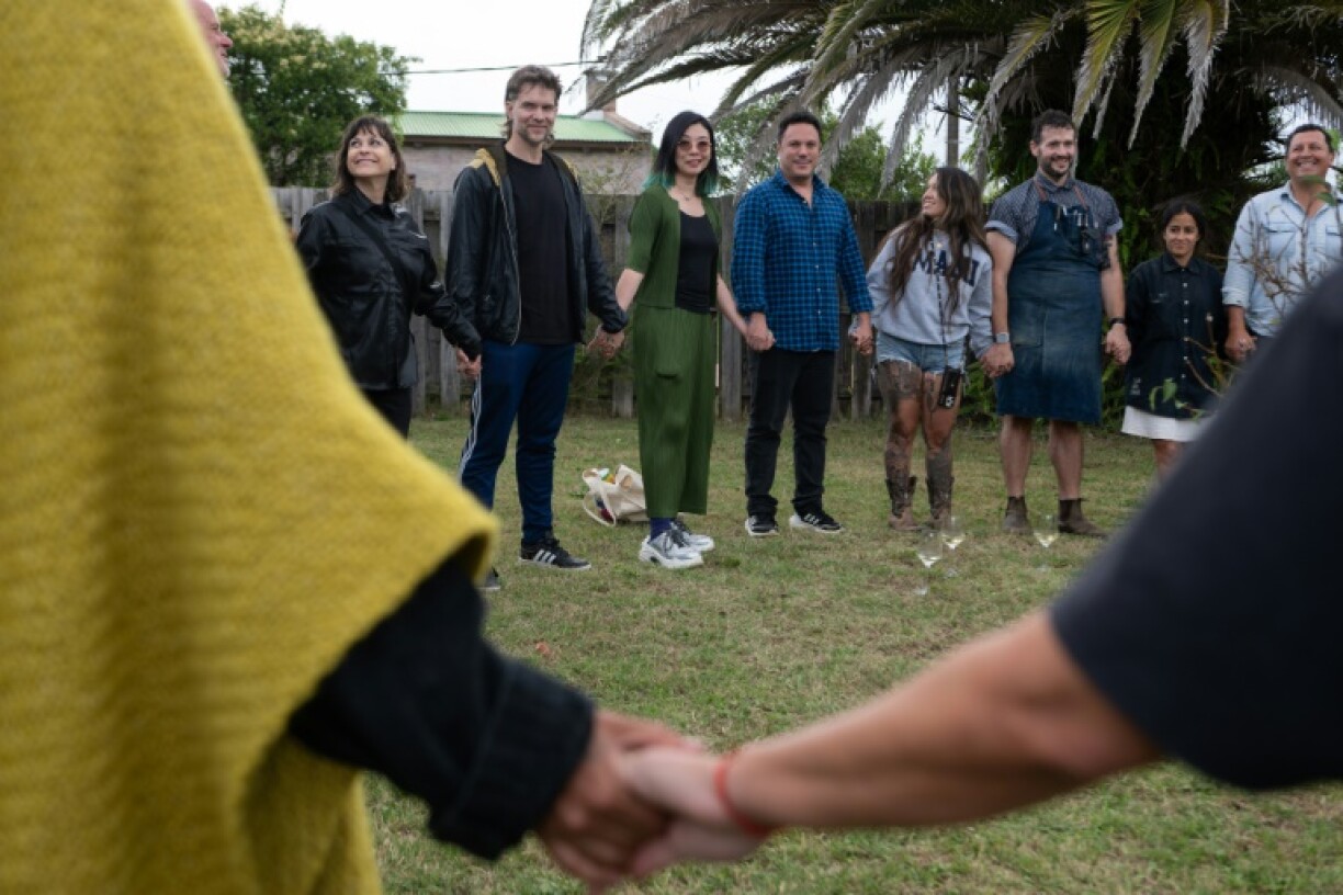 Artists hold hands in a circle at the opening of CAMPO Artfest