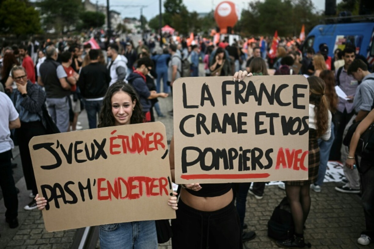 A protester with a placard, left, that reads 'I want to study, not accumulate debt' during a day of demonstrations in France last month