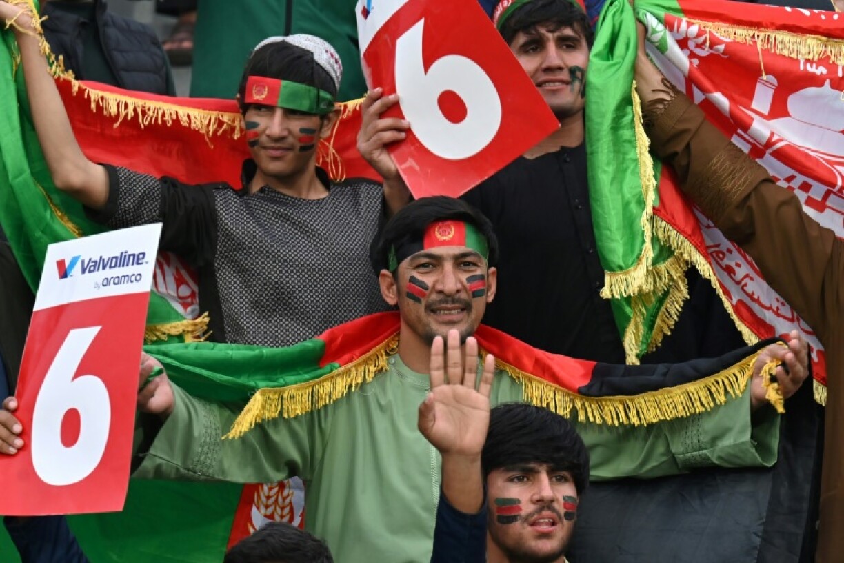 Afghans painted in red green and black cheer from Lahore and Kabul as their team seeks Champions Trophy cricket glory against England