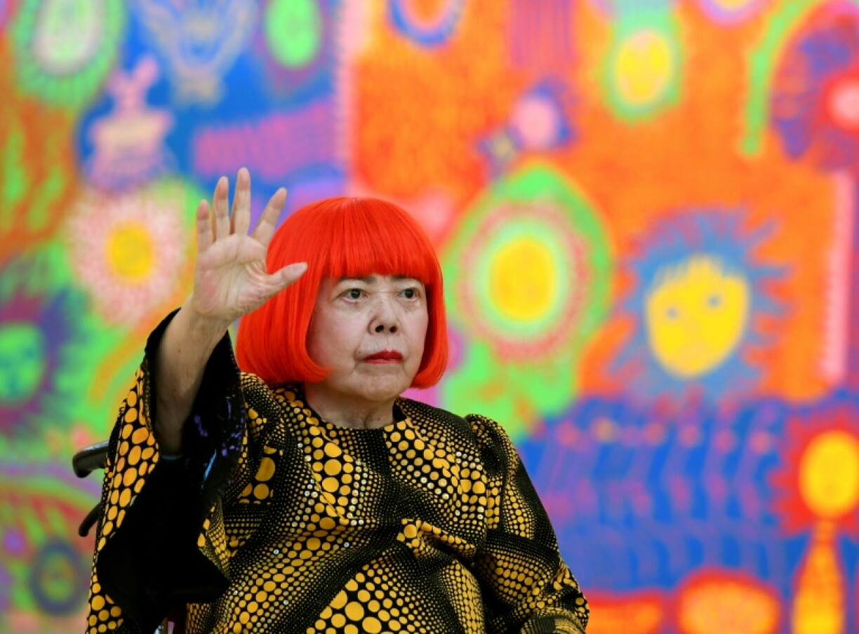 L'artiste japonaise Yayoi Kusama salue lors d’une séance photo pendant la préouverture presse de son exposition intitulée "Mon âme éternelle" au National Art Center de Tokyo, le 21 février 2017