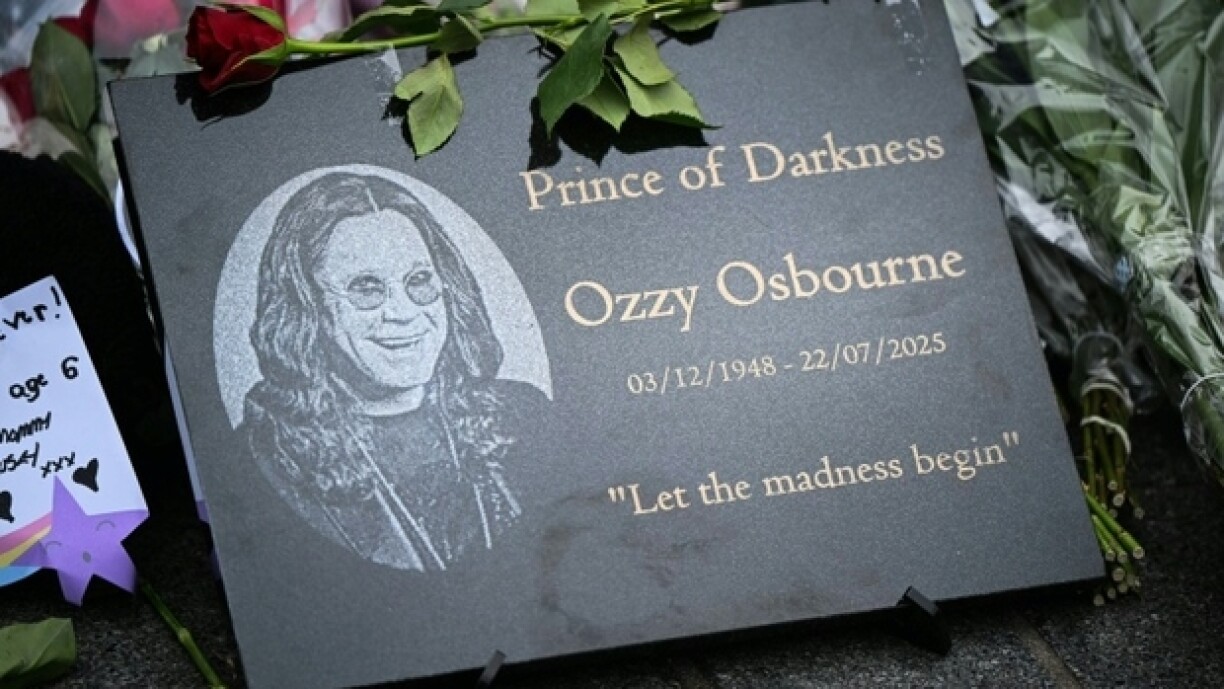 Une plaque commémorative déposée sur un mémorial improvisé près d'une fresque représentant Ozzy Osbourne, à Birmingham, dans le centre de l'Angleterre, le 23 juillet 2025