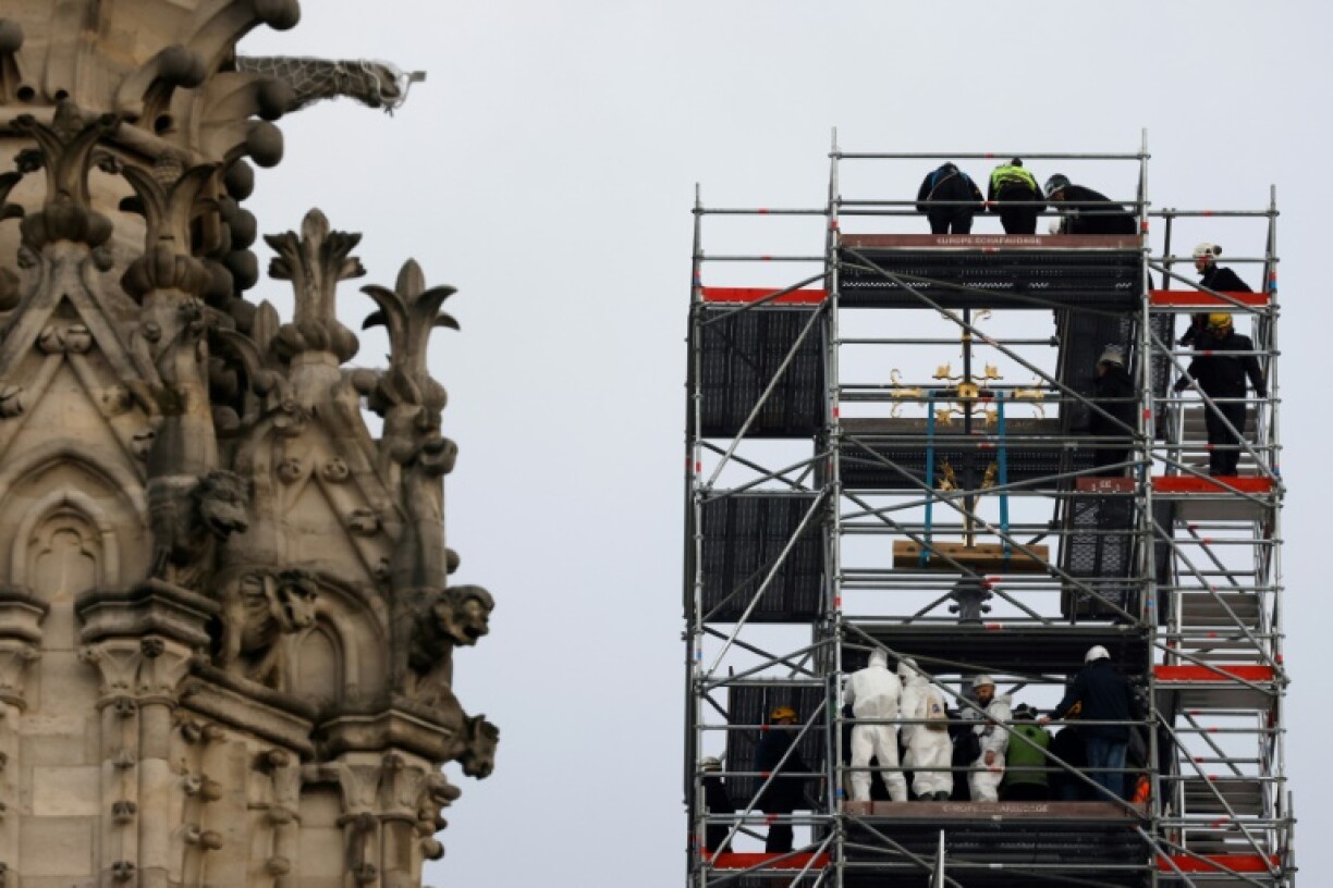 Des ouvriers posent la croix sur la flèche de Notre-Dame de Paris, le 6 décembre 2023