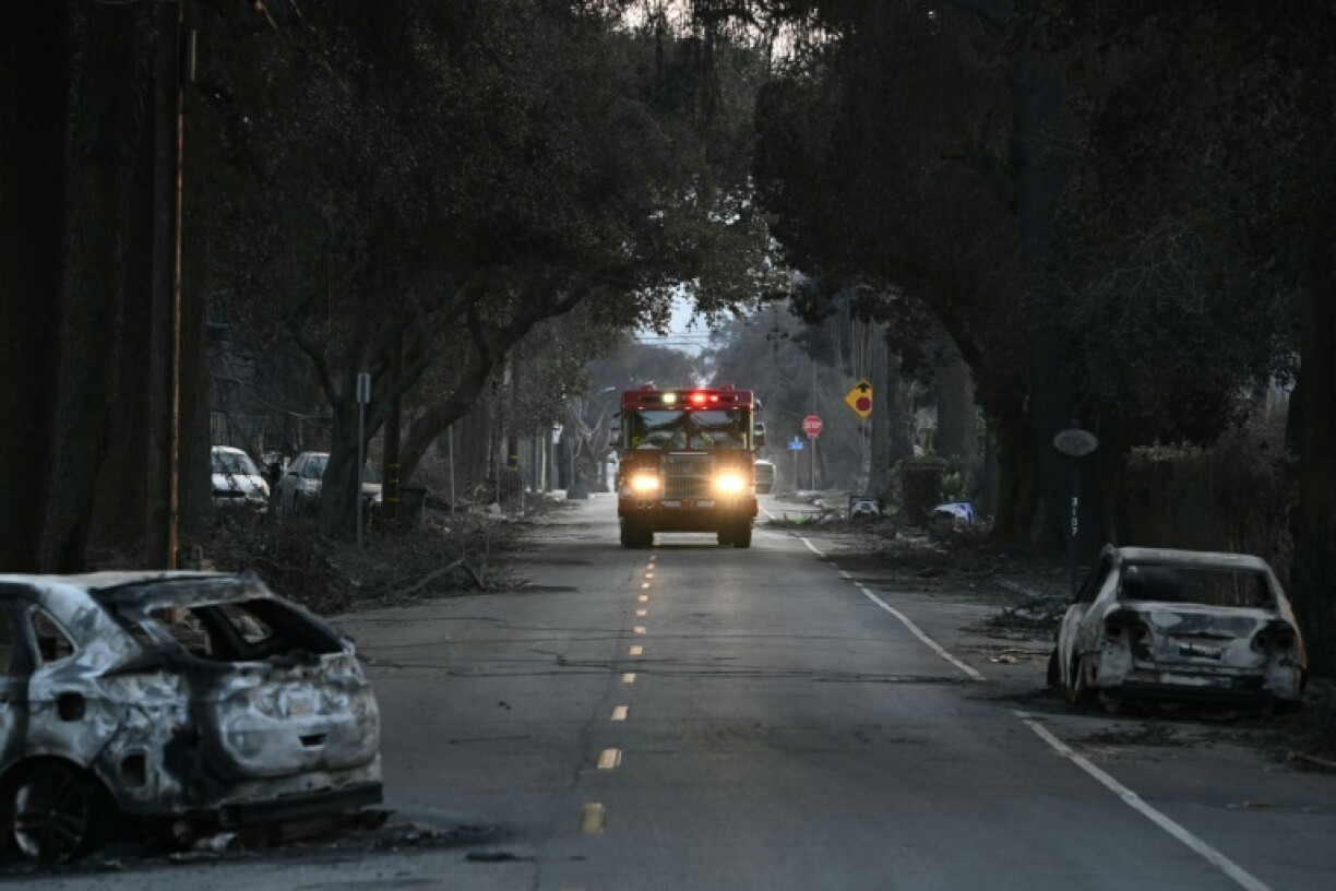 A firetruck drives past vehicles charred by the Eaton Fire in Altadena, California on January 10, 2025