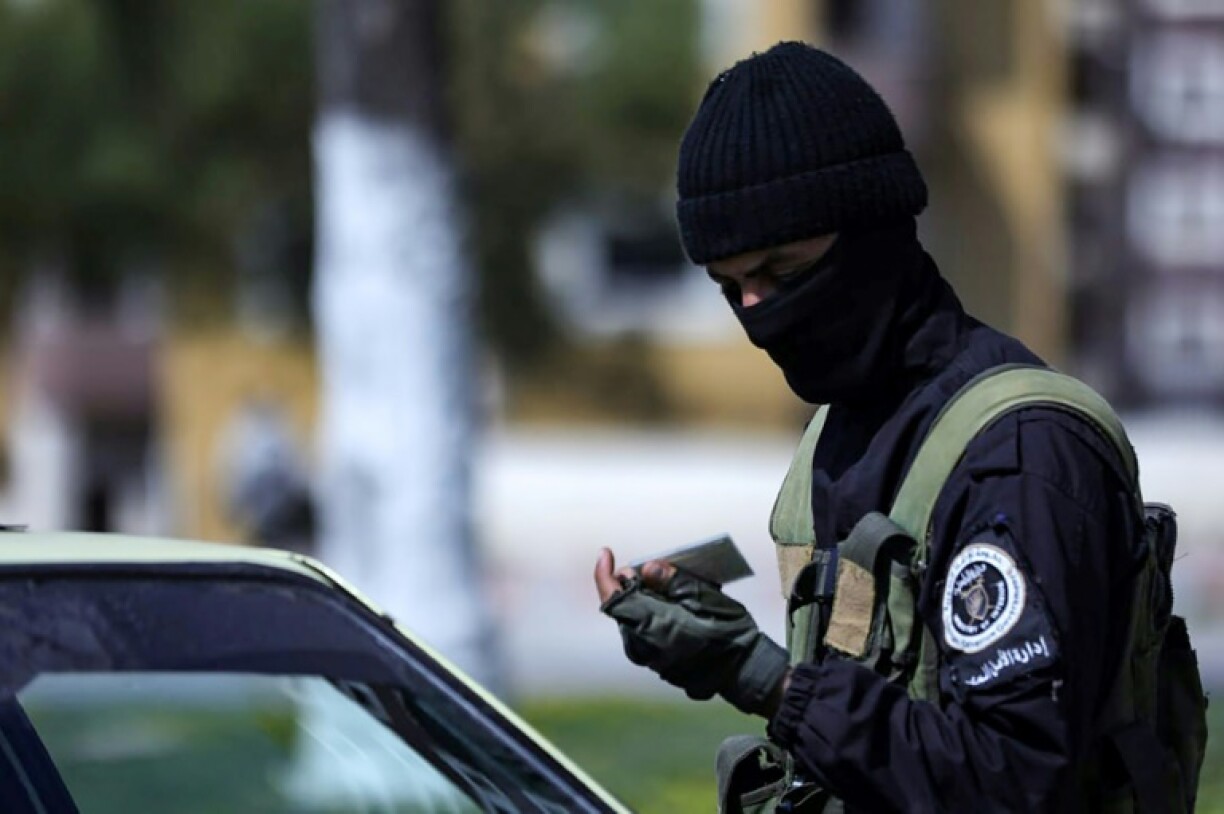 a picture released by the official Syrian Arab News Agency (SANA) shows a member of the Syrian forces checking the identity card of a driver at a checkpoint in Latakia, following deadly unrest