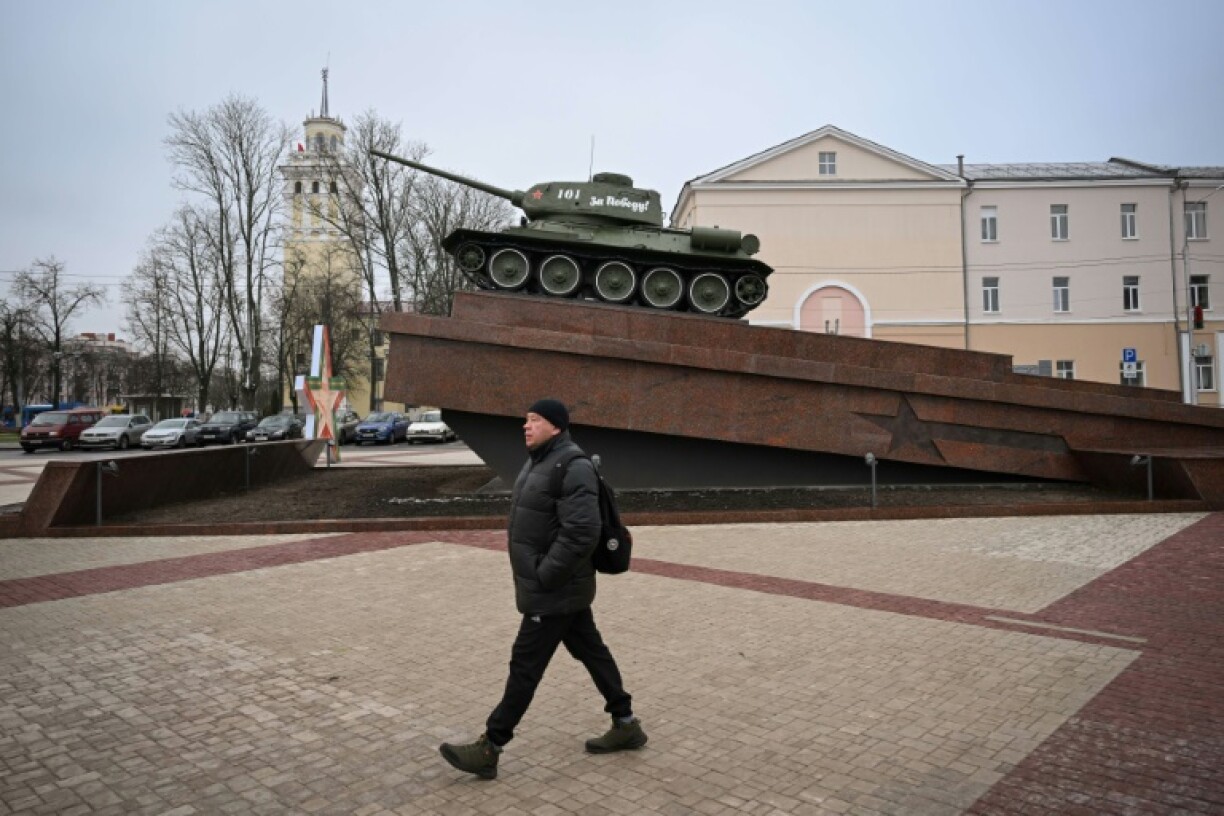 A man walks past a World War II monument featuring a Soviet-era tank in Gomel, a Belarus city near the Ukraine border
