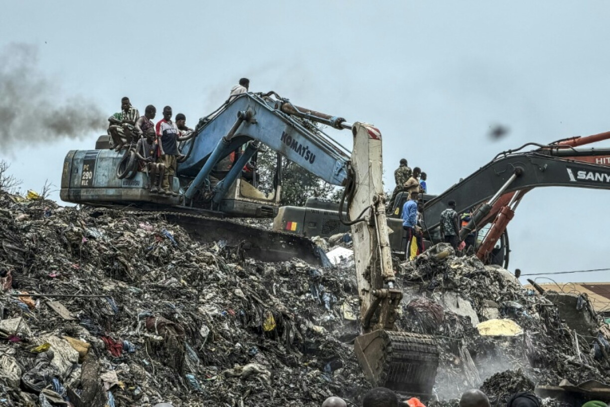 Des pelleteuses sont utilisées pour rechercher des corps, après l'effondrement d'une décharge sur des habitations à Dar es salam dans la banlieue de Conakry, le 23 août 2026
