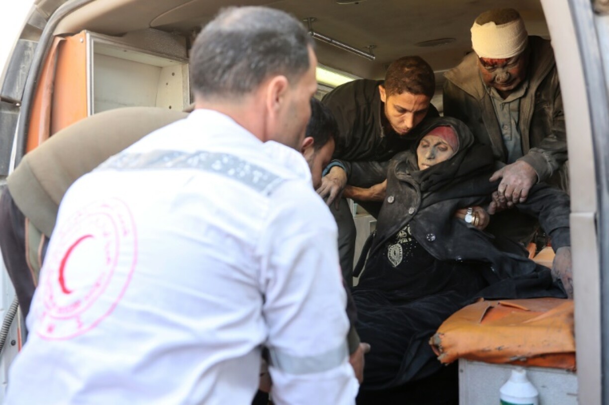 Paramedics put a wounded Palestinian woman into an ambulance in Gaza City