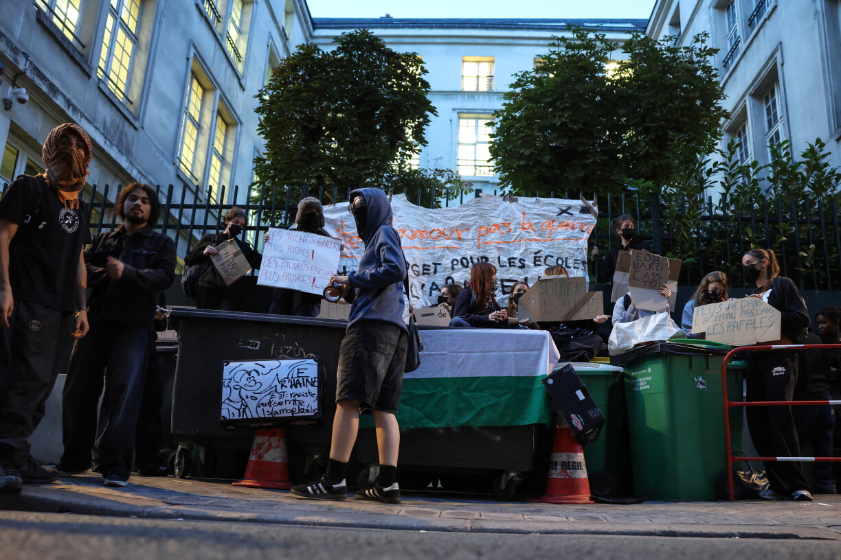 Students stand next to bins as they carry out a blocking protest at the Simone Veil secondary school during a day of nationwide public sector strikes and demonstrations in Paris on September 29, 2026.