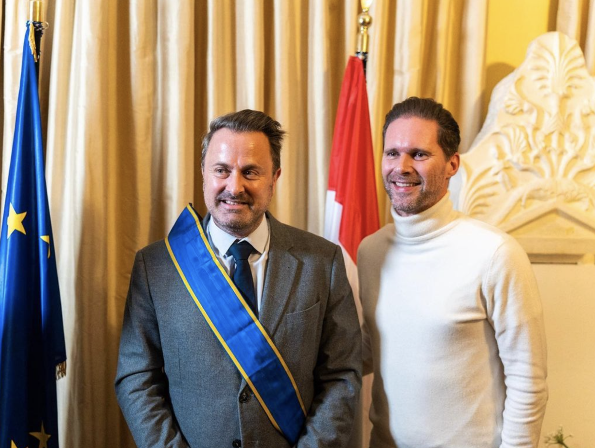 Prime Minister Xavier Bettel wearing the rybon bestowed upon him by the Greek Ambassador, with his husband Gauthier Destenay (right).