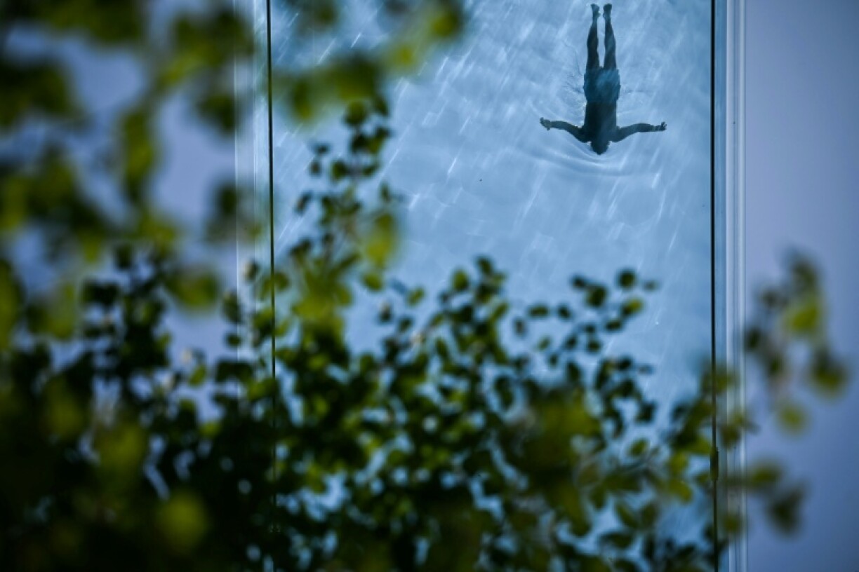 A person swims in the Sky Pool, a transparent acrylic swimming pool bridge in London, as the Met Office reports the UK has had its sunniest spring since records began with 630 hours of sunshine between March 1 and May 27