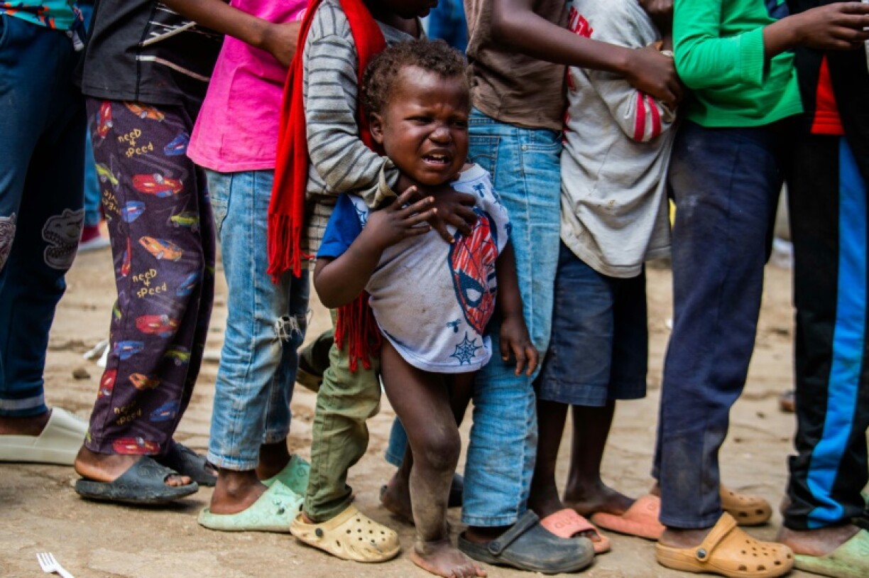 Children wait for food at a shelter for families displaced by gang violence in Port-au-Prince on February 10, 2025