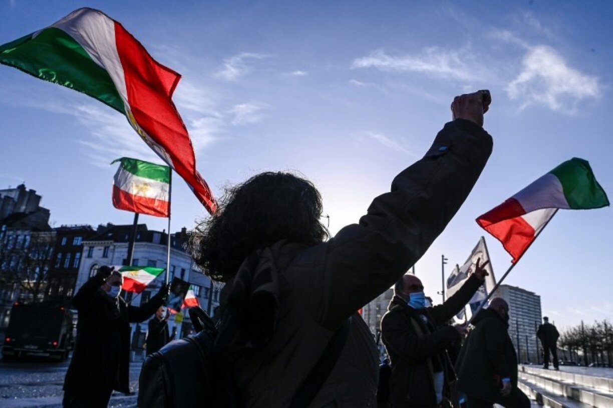 Des personnes manifestent le 4 février 2021 devant le tribunal d'Anvers, en Belgique, en agitant d'anciens drapeaux iraniens.