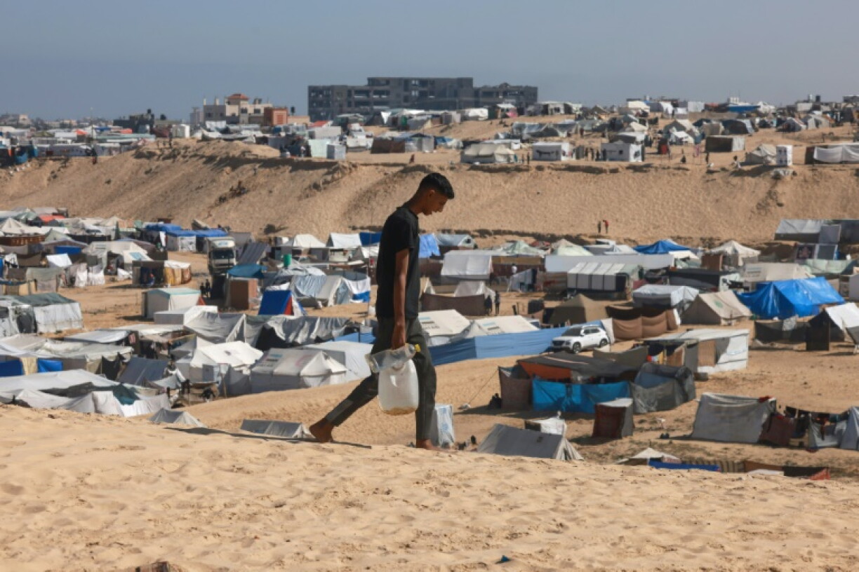 Un Palestinien transporte de l'eau dans un camp de déplacés à Rafah, dans le sud de la bande de Gaza, le 4 avril 2024