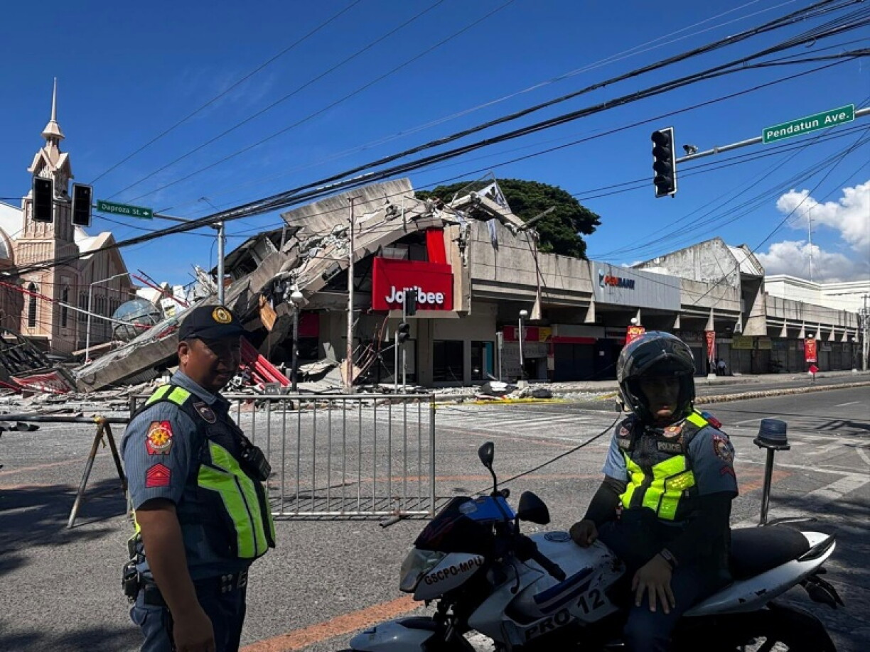 La police se rassemble devant un restaurant de fast-food Jollibee effondré après un séisme de magnitude 7,8 dans la ville de General Santos aux Philippines le 8 juin 2026