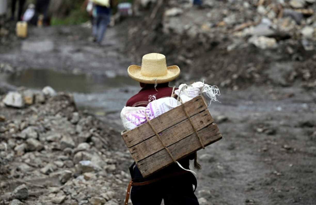 A local walks past a landslide at the entrance to the town of San Bartolo Tutotepec in Hidalgo state, Mexico