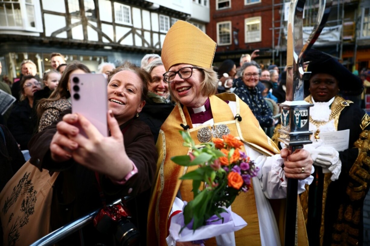 La nouvelle archevêque de Canterbury, Sarah Mullally, pose pour une photo avec une fidèle à Buttermarket après sa cérémonie d'intronisation à la cathédrale de Canterbury, dans le sud-est de l'Angleterre, le 25 mars 2026