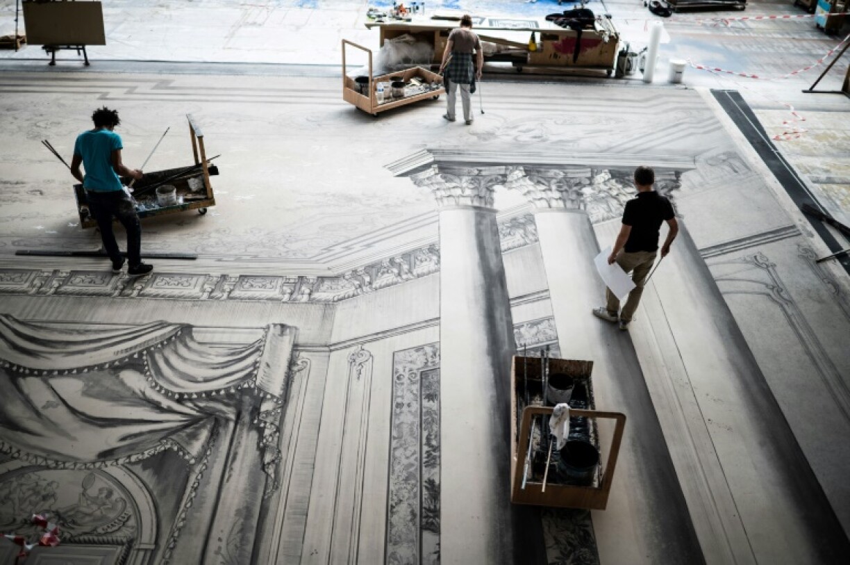 Des peintres travaillent sur des grandes toiles en trompe-l'oeil du décor en noir et blanc du ballet