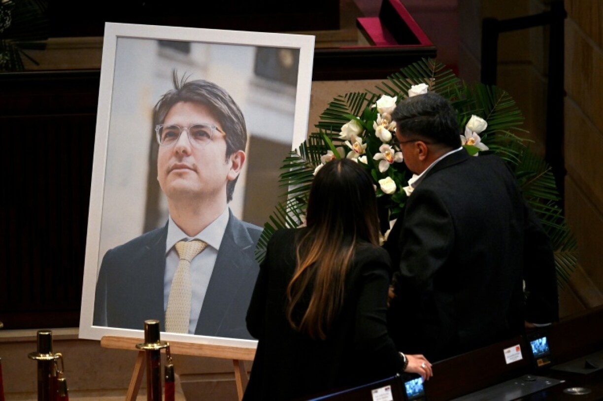 People stand in front of a tribute in Congress to late Colombian presidential candidate Miguel Uribe, who died two months after being shot in the head at a campaign event