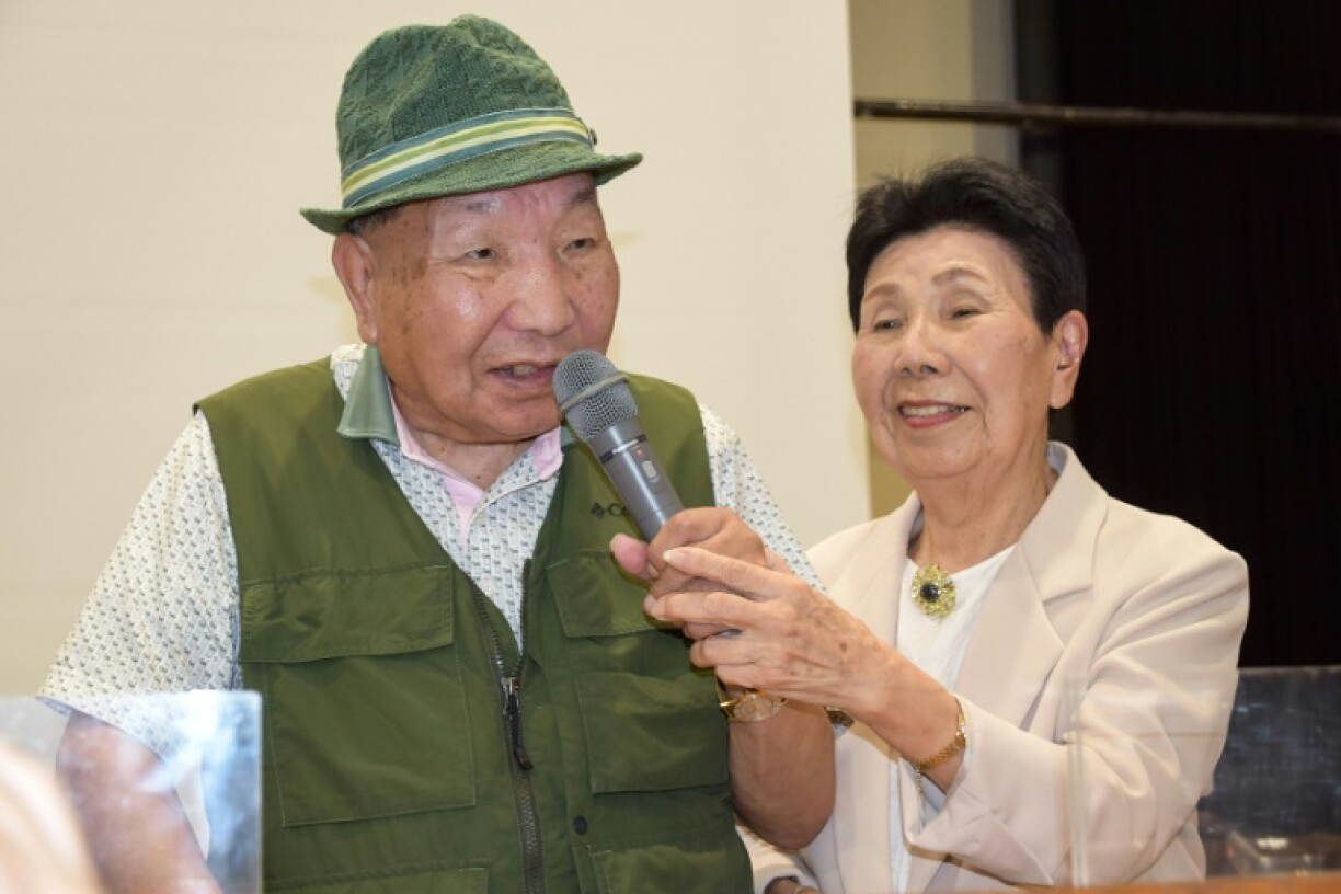 This photo taken in September 2024 shows Iwao Hakamada (L) speaking as his sister Hideko holds the microphone