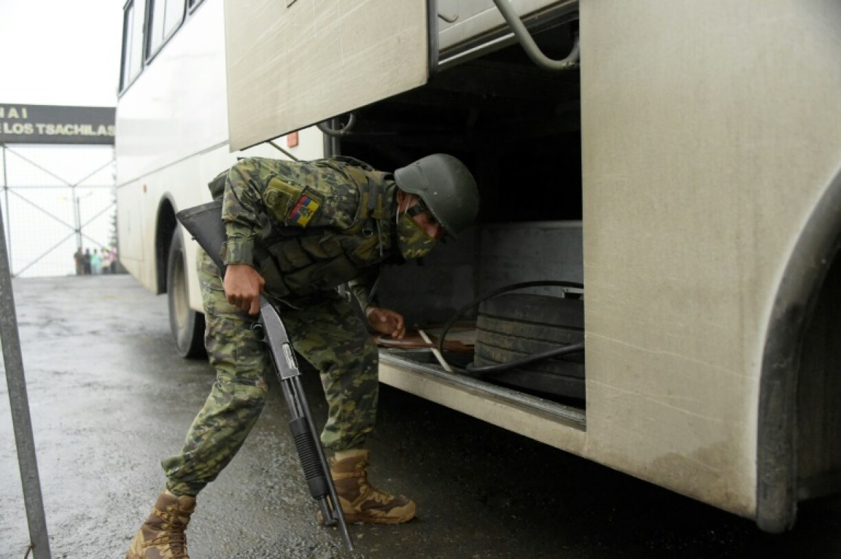 Un soldat inspecte un bus devant la prison de Bellavista, dans la province de Santo Domingo de los Tsachilas (Equateur), le 10 mai 2022