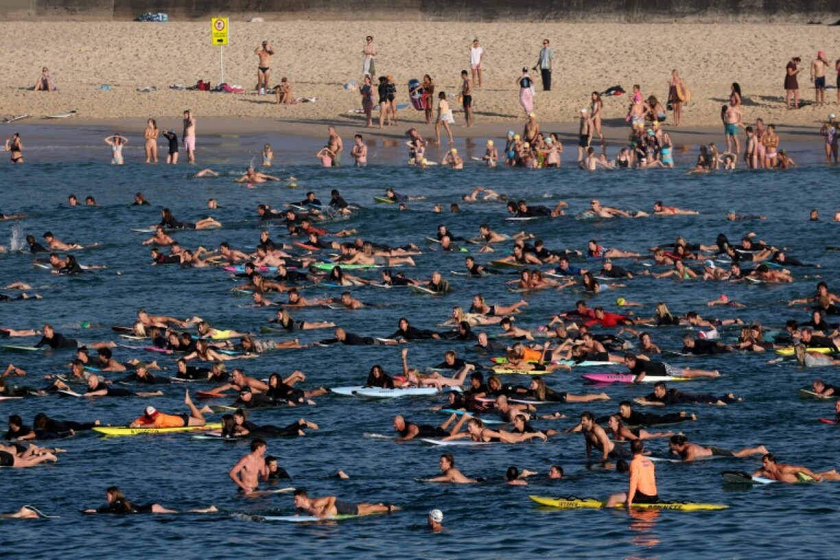 Des surfeurs et des nageurs se sont rassemblés au large de la plage de Bondi, pour rendre hommage aux victimes de l'attentat qui s'y est produit, à Sydney, le 19 décembre 2025