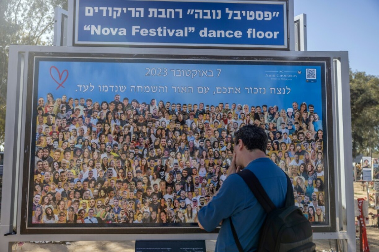 A man views a billboard depicting images of the Nova music festival victims