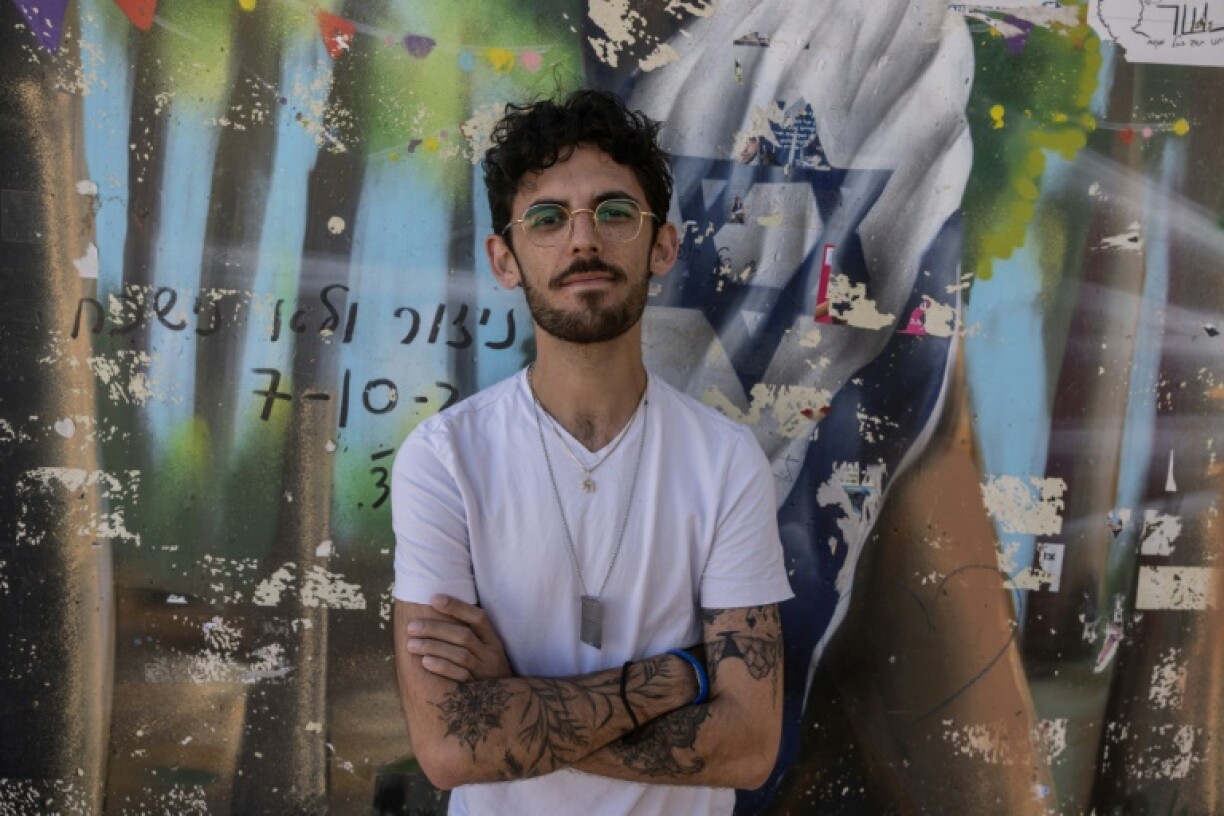 Shye Klein-Weinstein, a 28-year-old survivor of the October 7, 2023 attacks by Palestinian militants, poses for a picture next to a memorial to the Nova music festival victims