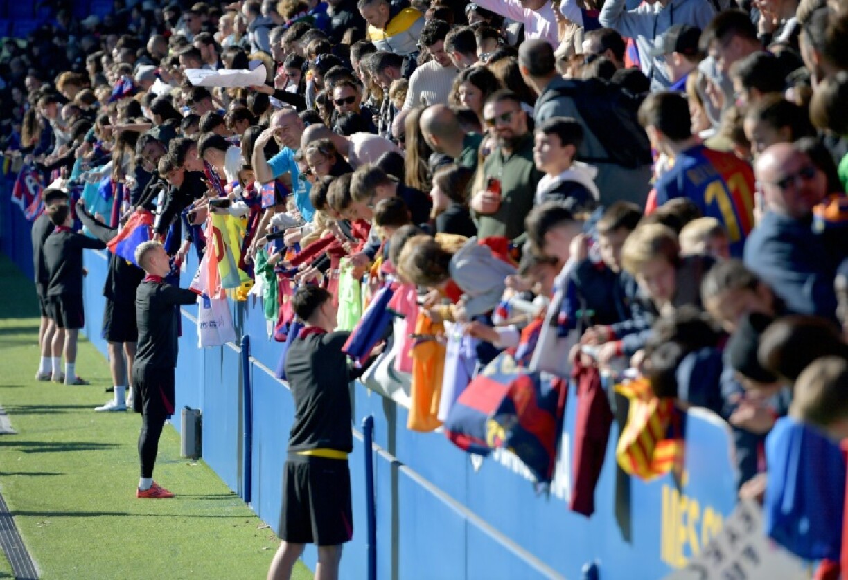 Barcelona's Spanish forward Dani Olmo and teammates sign autographs for fans at an open training session