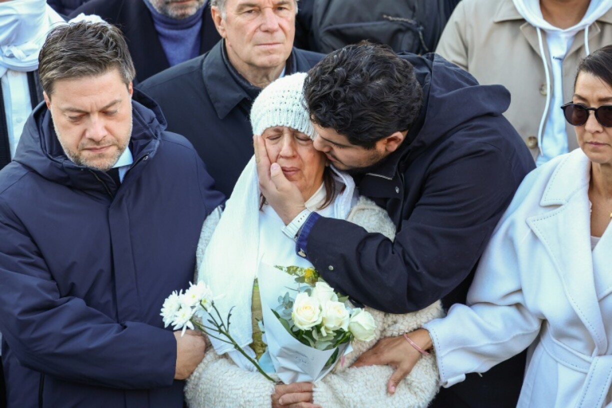 Amine Kessaci (G)console sa mère Ouassila Benhamdi (C) au côté du maire de Marseille Benoît Payan (D) lors de l'hommage à son fils assassiné Mehdi Kessaci, organisé à Marseille le 22 novembre 2025
