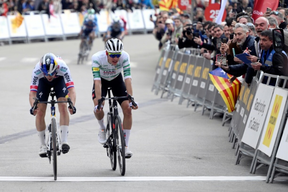 Team Bora's Primoz Roglic (L) crosses the finish line in first place followed by Team UAE's Juan Ayuso