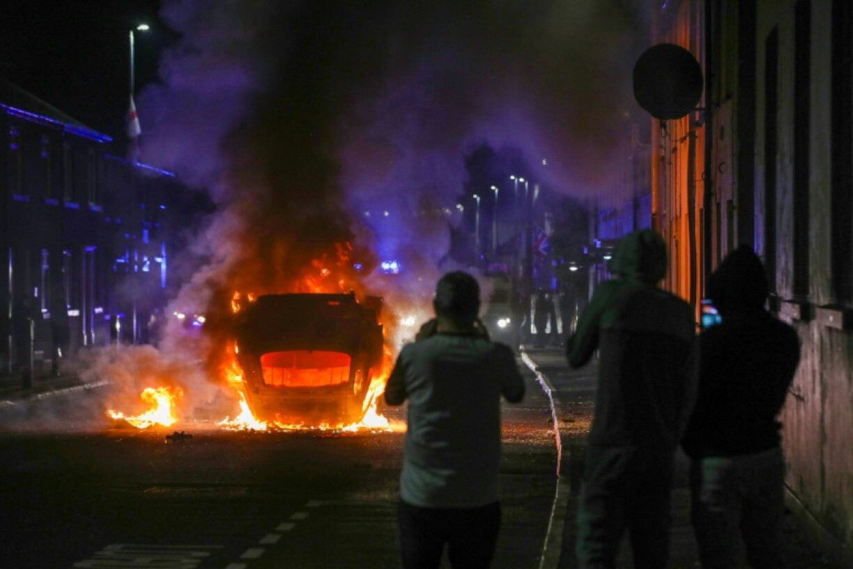 Un véhicule incendié lors d'une manifestation anti-immigration à Ballymena, après l'arrestation de deux adolescents roumanophones accusés d'avoir tenté de violer une jeune fille, le 10 juin 2025 en Irlande du Nord