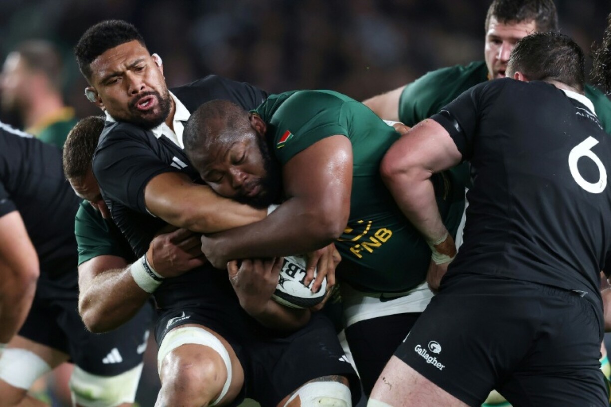 Ox Nche of South Africa is tackled by Ardie Savea