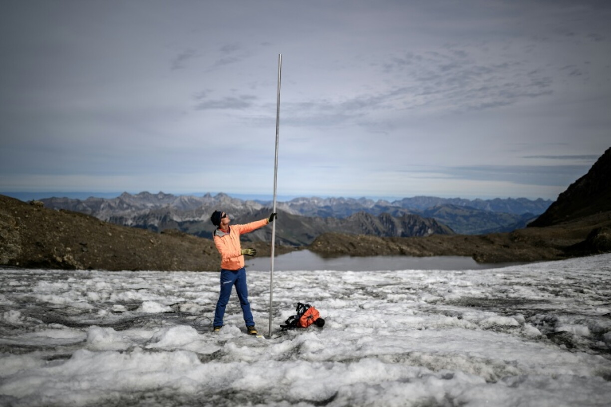 Matthias Huss with a four-metre-long measuring stake indicating the amount of ice that melted over the past year on the Scex Rouge glacier