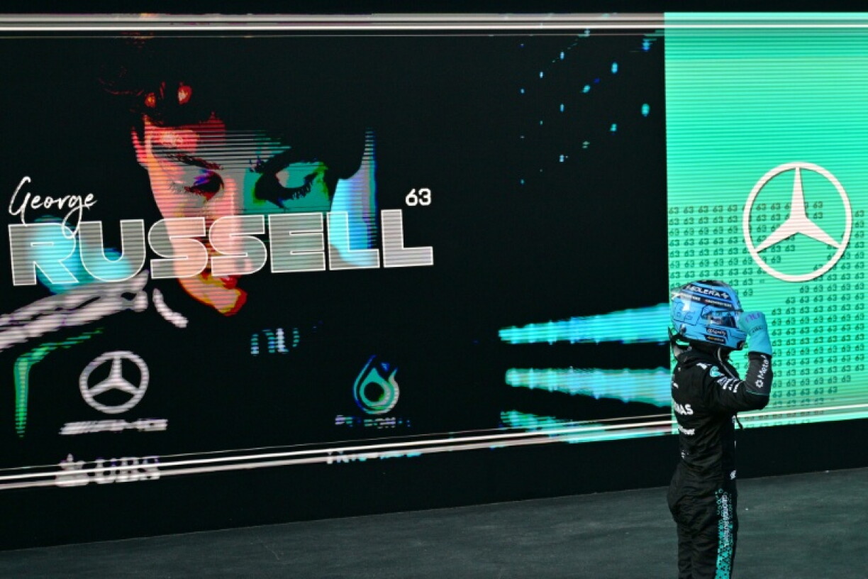 George Russell celebrates victory on the Baku podium watched by his virtual self