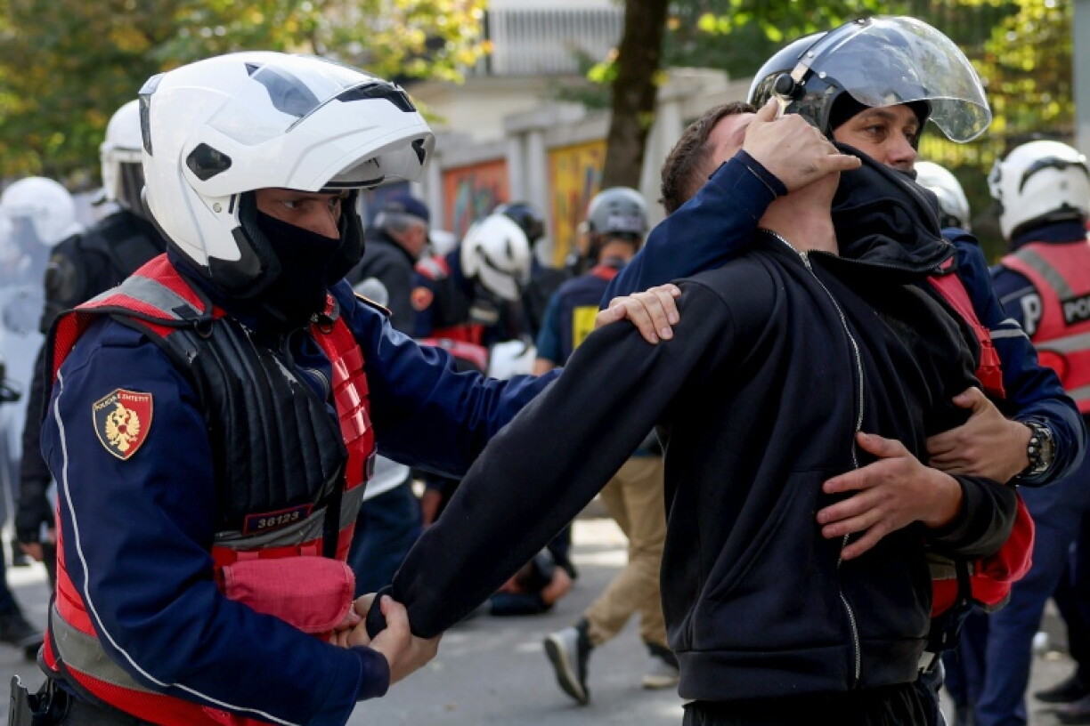 Police detain a protester during an anti-government demonstration in central Tirana on October 15, 2026, as protests continued for a third consecutive day over university conditions and demands for the resignation of Albanian Prime Minister Edi Rama. The latest rally follows two nights of violence in the capital, during which protesters and riot police clashed, police used water cannons and tear gas, and demonstrators damaged government offices and shops and set fire to several buildings.
