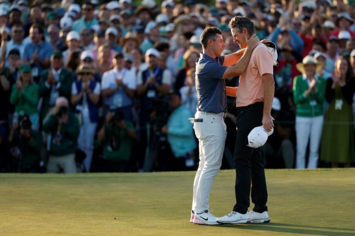 Rory McIlroy of Northern Ireland shakes hands with Justin Rose after beating the Englishman in a playoff to win the Masters