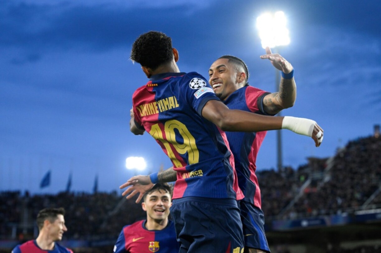 Raphinha (R) celebrates scoring the opening goal with Lamine Yamal (L) as Barcelona beat Benfica