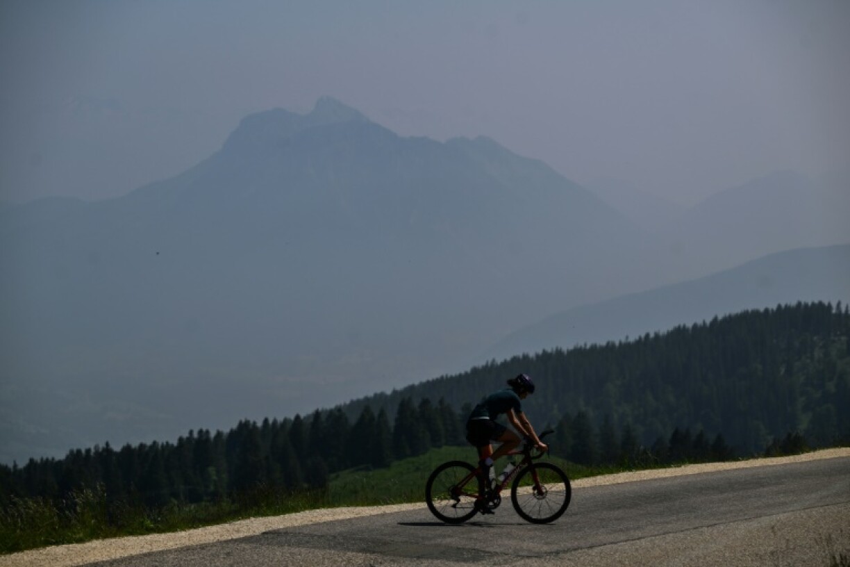 A ciclyst rides in front of the Bauge massif and the alps from the Semnoz Mountain, on the day heavy smoke from intense wildfires in Canada reached France, in the French Bauges Mountain range, on June 11, 2025