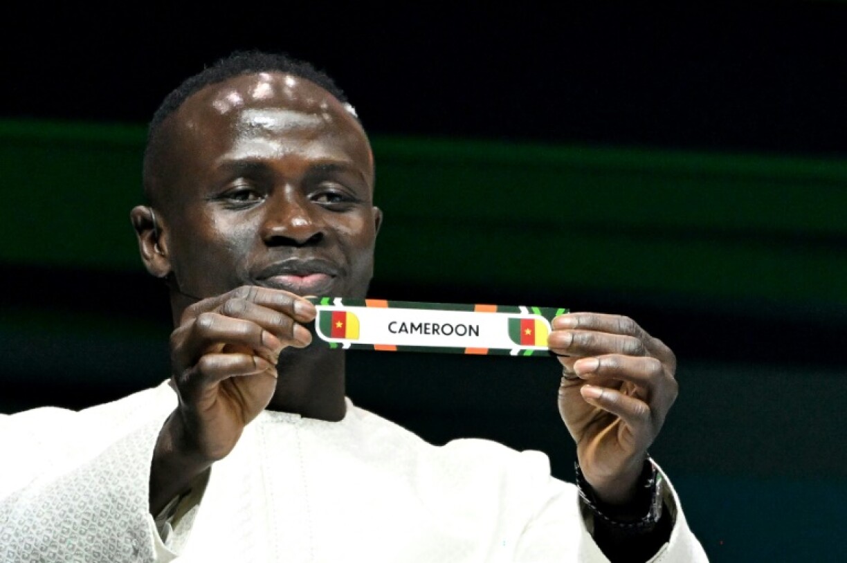 Le footballeur sénégalais Sadio Mane montre le papier de l'équipe du Cameroun, qu'il va affronter, lors du tirage au sort de la CAN à Abidjan le 12 octobre 2023