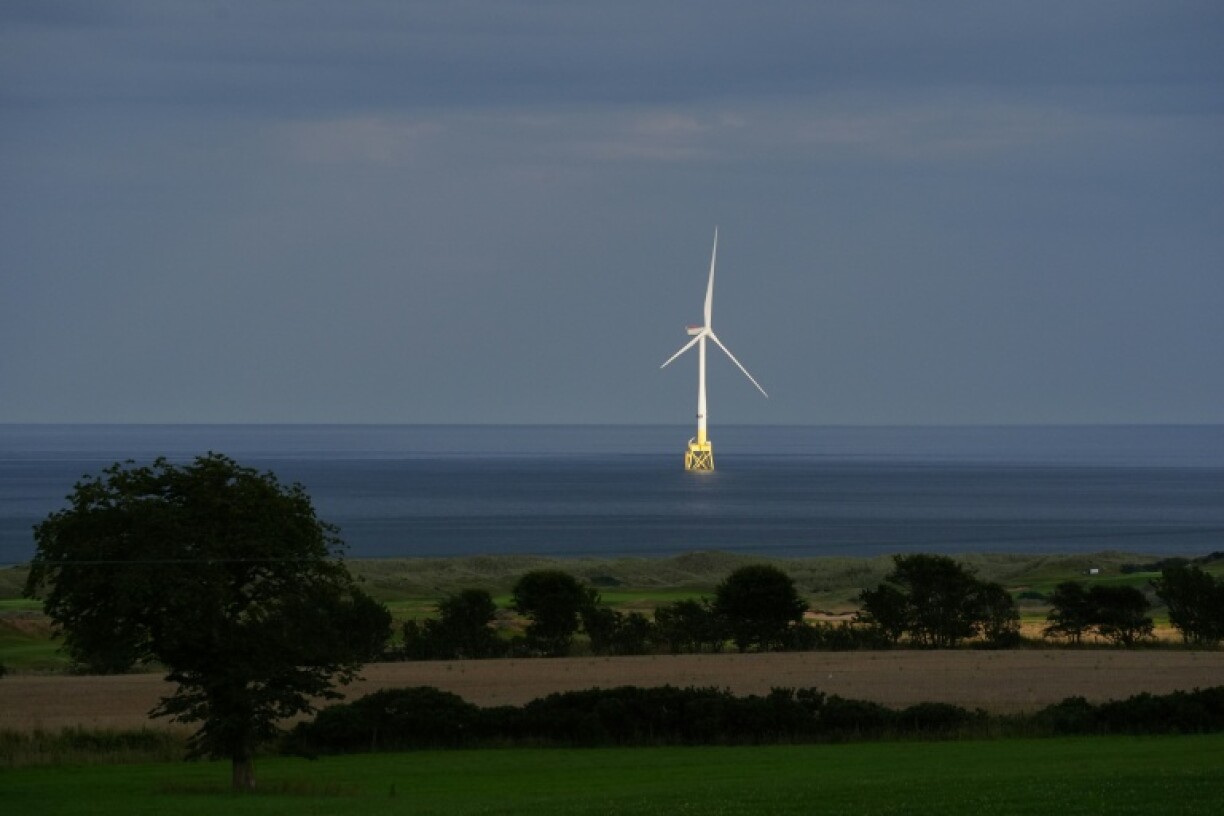 A wind turbine is seen in the sea behind the Trump International Golf Links course in Balmedie, Aberdeenshire