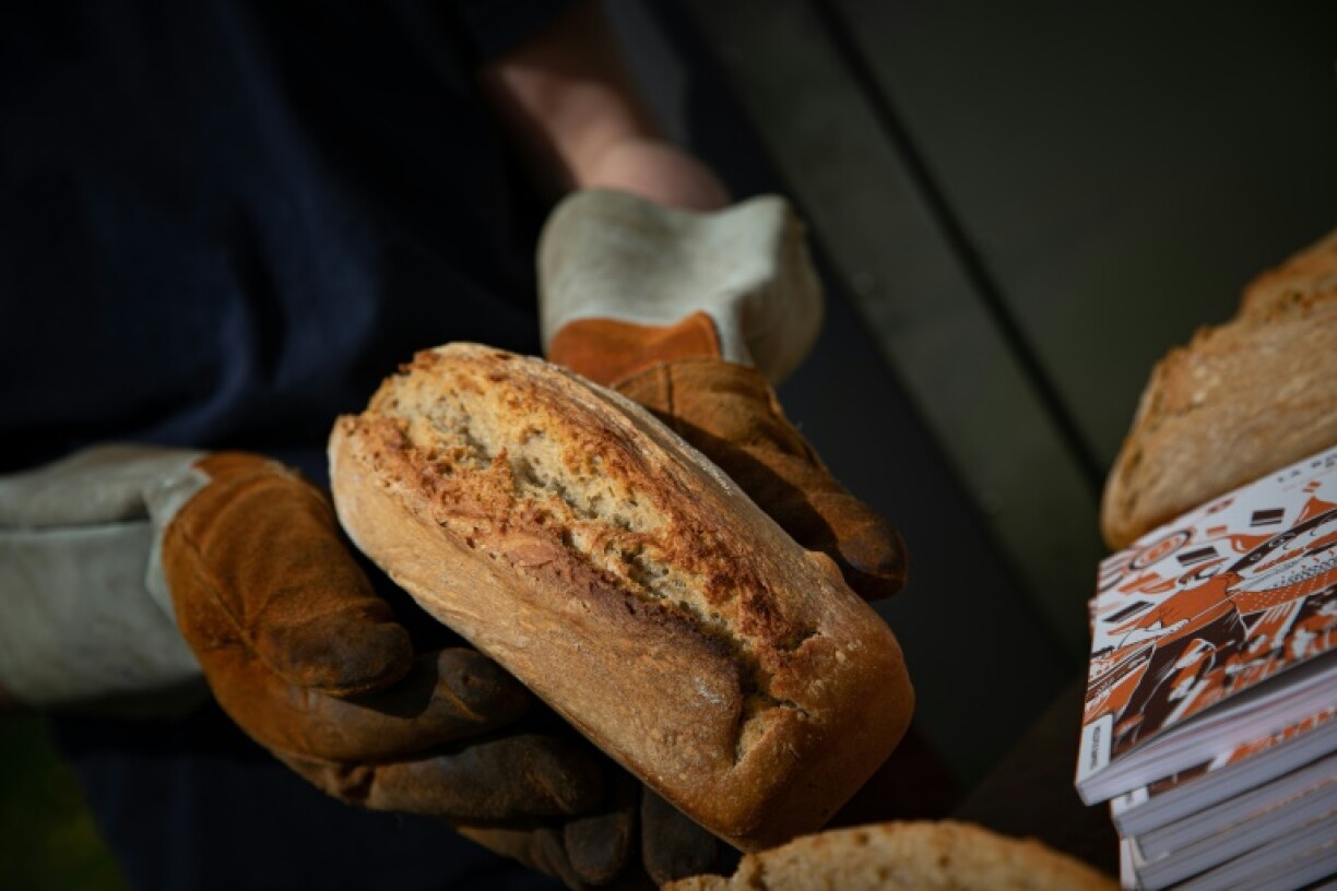 Le boulanger-torréfacteur Arnaud Crétot montre son pain cuit dans un four solaire, le 2 mai 2023 à Montville, près de Rouen, en Normandie