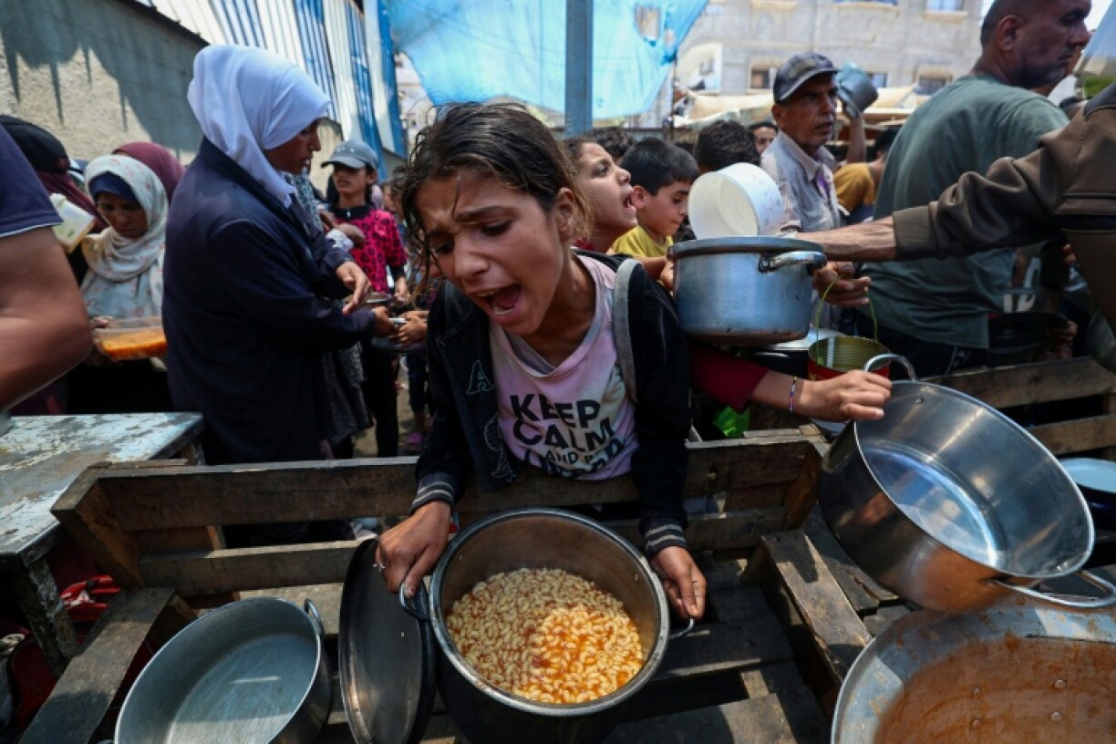 Palestinians queue at an aid kitchen in Nuseirat in central Gaza