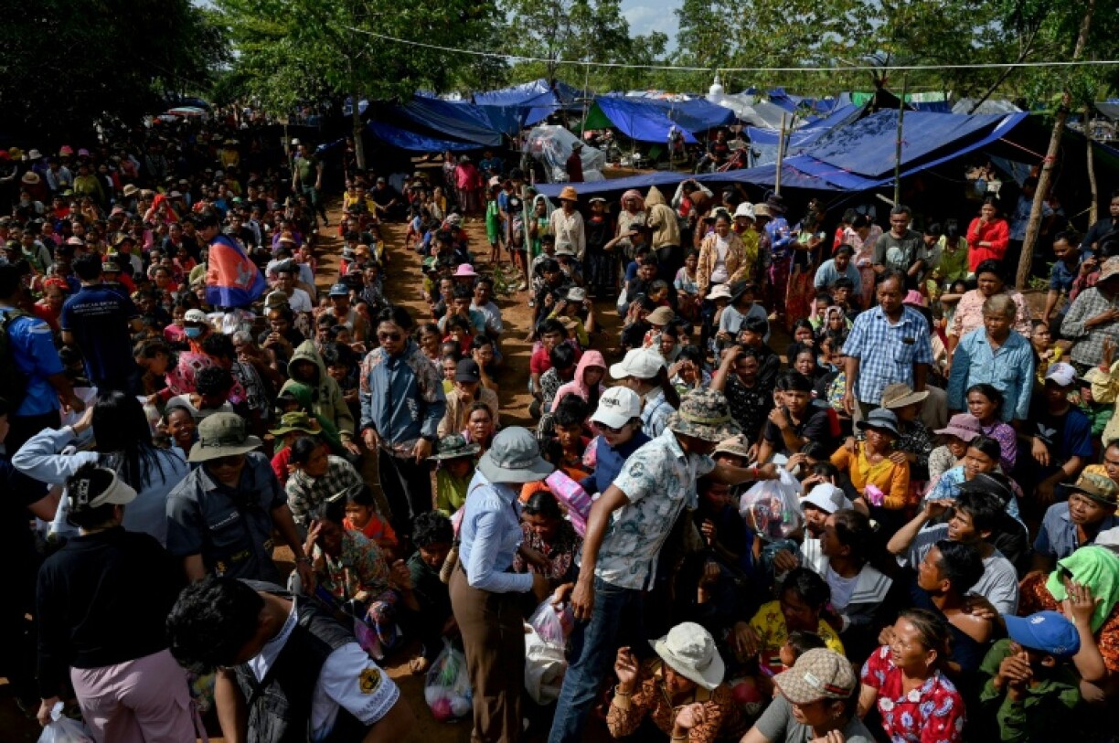 People who fled their homes near the border between Cambodia and Thailand gather at a food distribution site on the grounds of a pagoda in Oddar Meanchey province, Cambodia