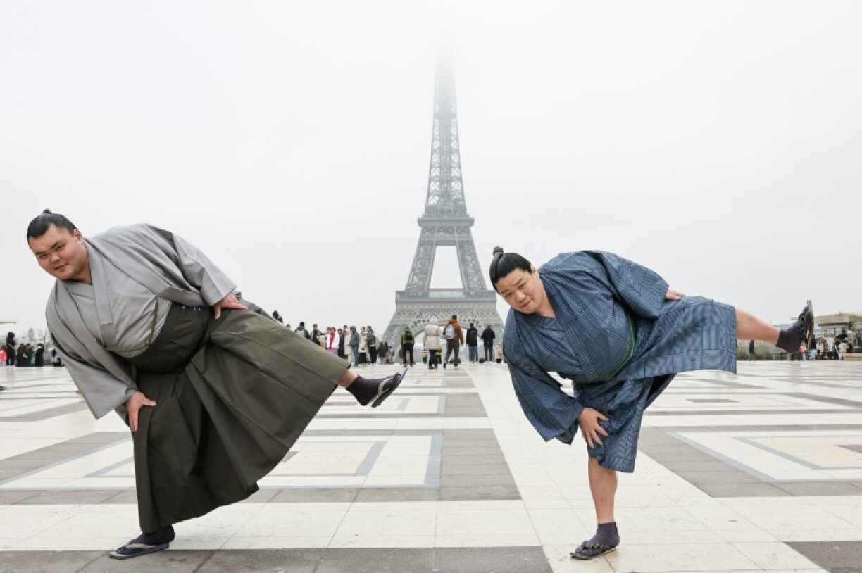 Tochitaikai (L) and Tochikodai pose in for a photo in front of the Eiffel Tower as they promote a sumo tournament in Paris in 2026