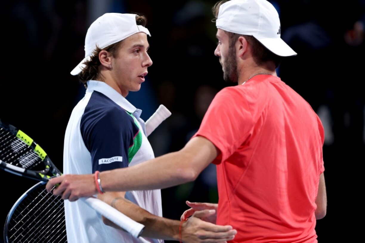 Britain's Jacob Fearnley (R) shakes hands with France's Arthur Cazaux after their match on the Australian Open's 'party court'