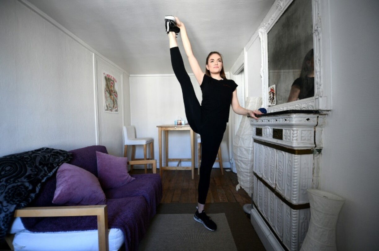 Une danseuse du Moulin Rouge, Courtney, pratique des exercices de souplesse chez elle, le 14 avril 2020