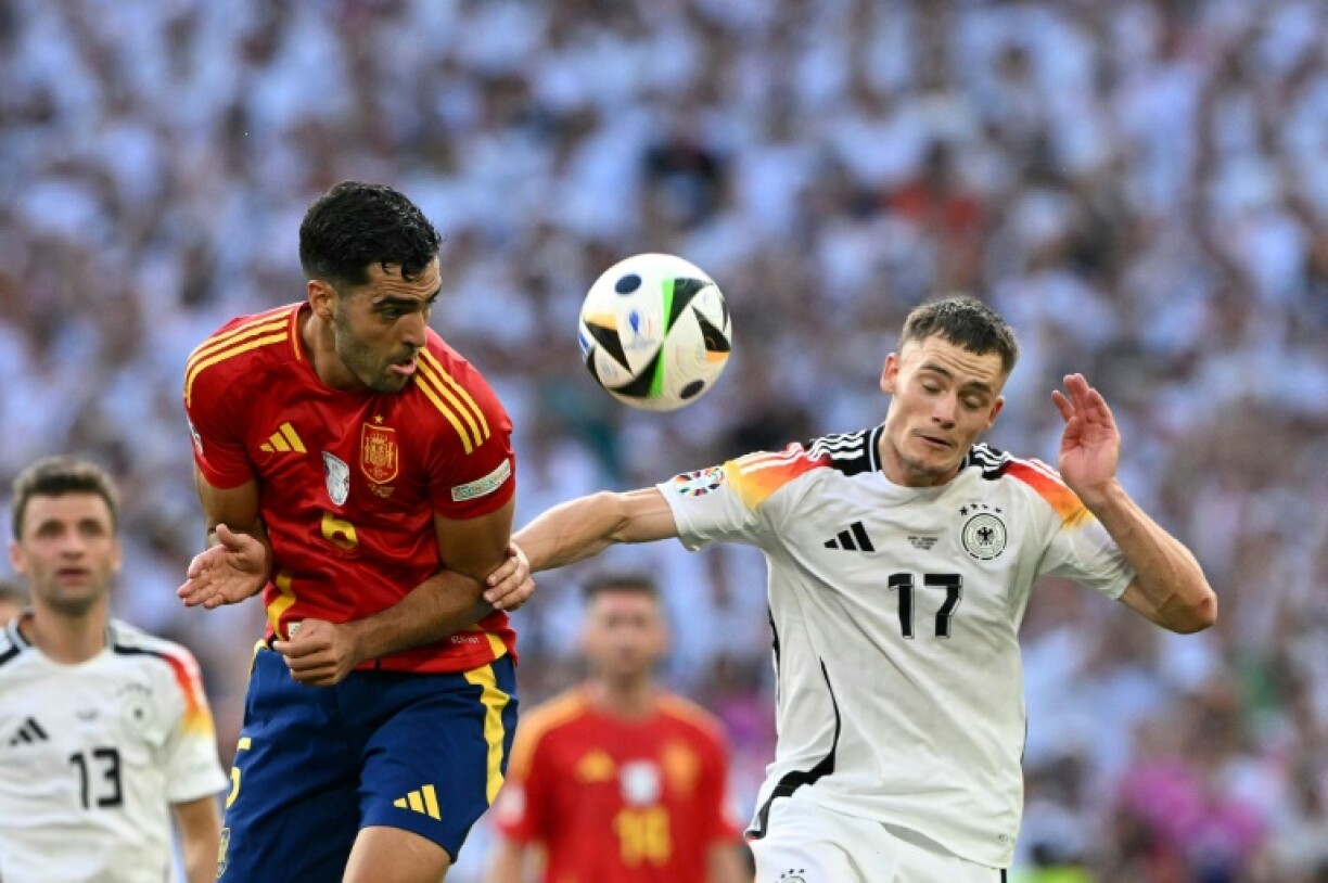 Spain's midfielder Mikel Merino fights for the ball with Germany's midfielder Florian Wirtz at Euro 2024