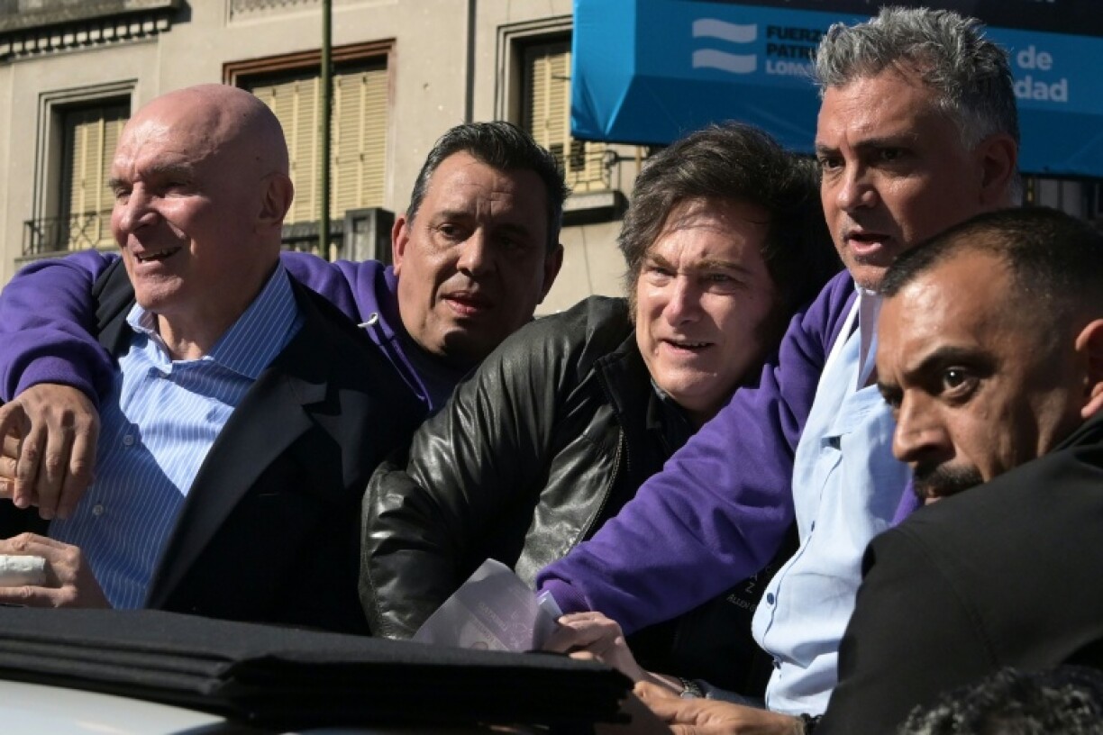 Milei as protesters throw objects at them during a motorcade in Lomas de Zamora, Buenos Aires province
