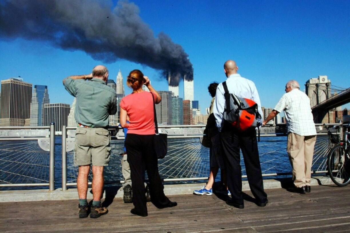 Des piétons regardent les tours du World Trade Center qui ont été heurtées par deux avions de ligne, le 11 septembre 2001 à New York.