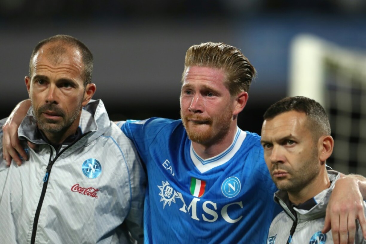 Kevin De Bruyne leaves the pitch with Napoli's medical staff after suffering the injury in the win over Inter Milan